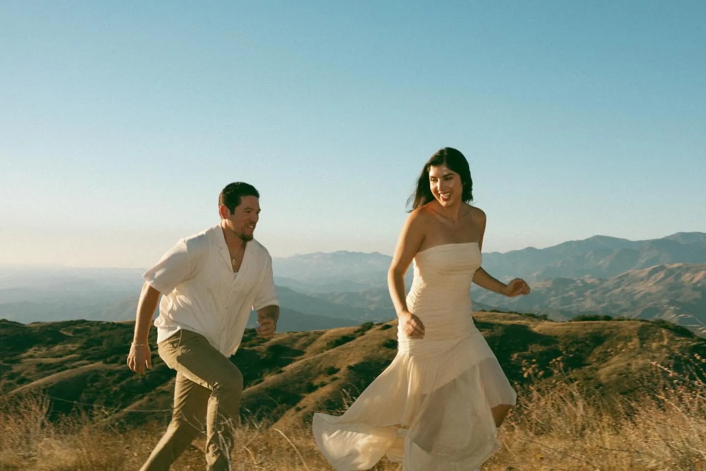 Couple walking through golden grass in the Santa Barbara hills
