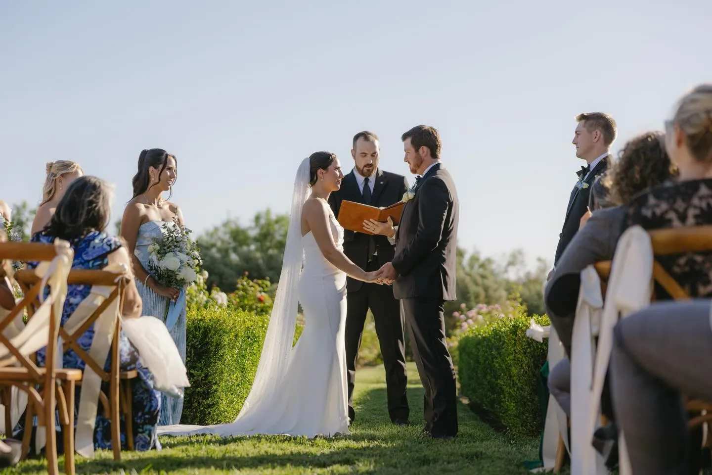 Bride and groom exchanging vows during an outdoor ceremony